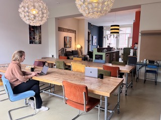 Flexwerken aan een grote houten tafel in de Bank van Noppes in Gorinchem